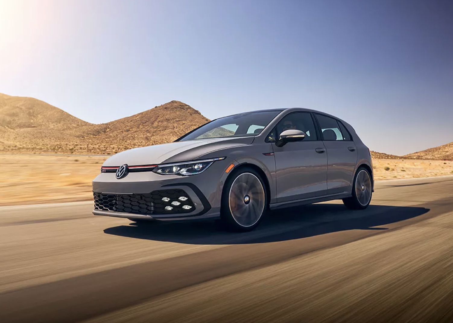 Volkswagen Golf driving at high speeds through the desert.