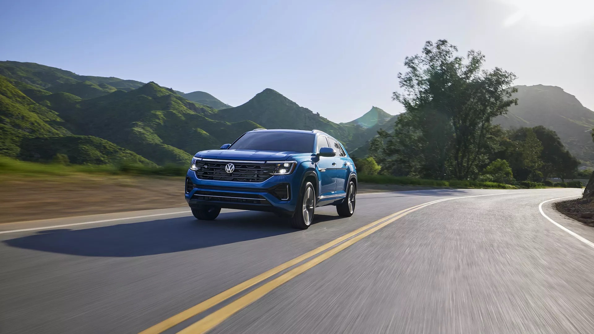 A Blue 2025 VW Atlas driving down road in Rockford, IL