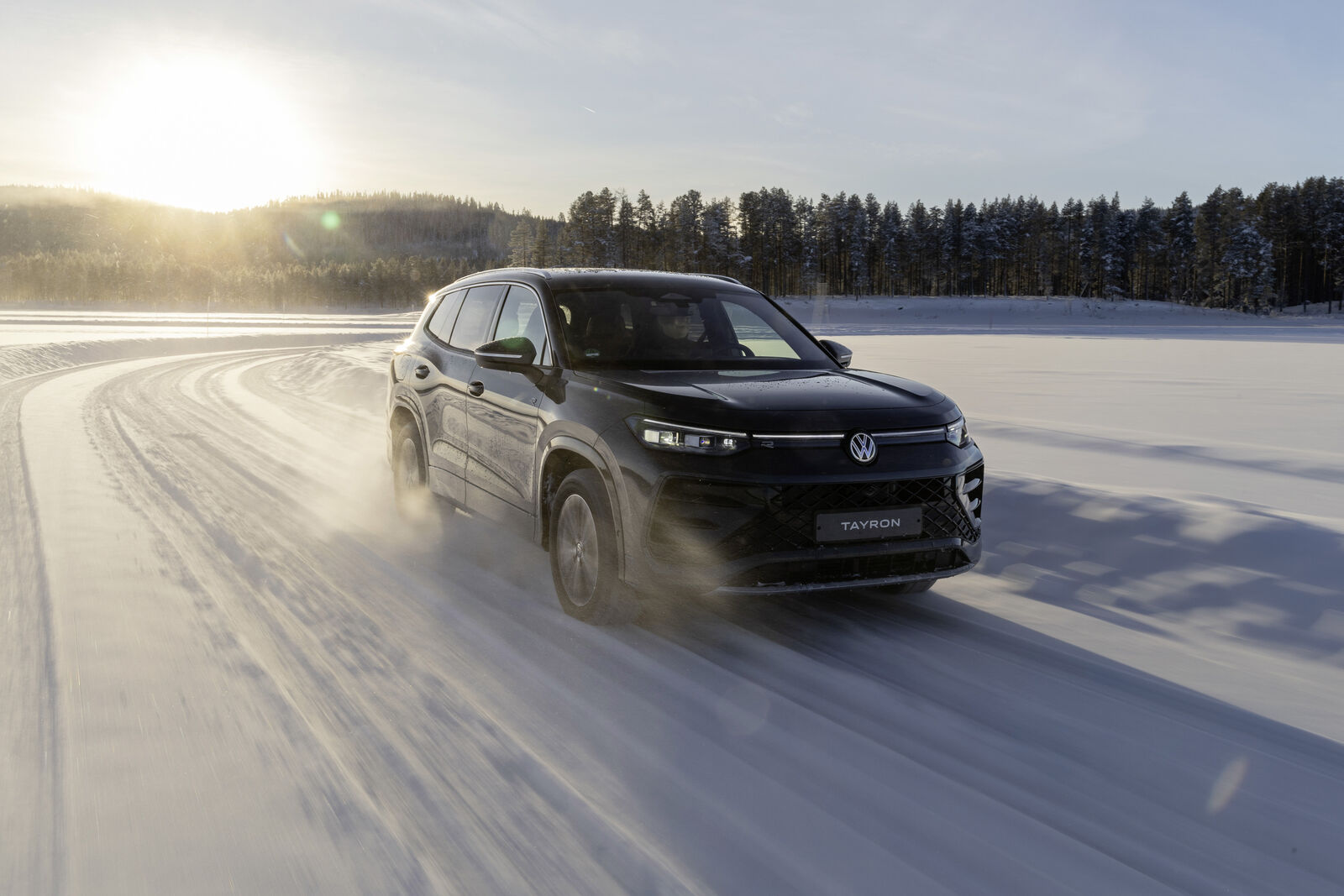 A 2026 black VW vehicle driving through snow